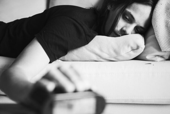 A sleepy Caucasian man turning an alarm off