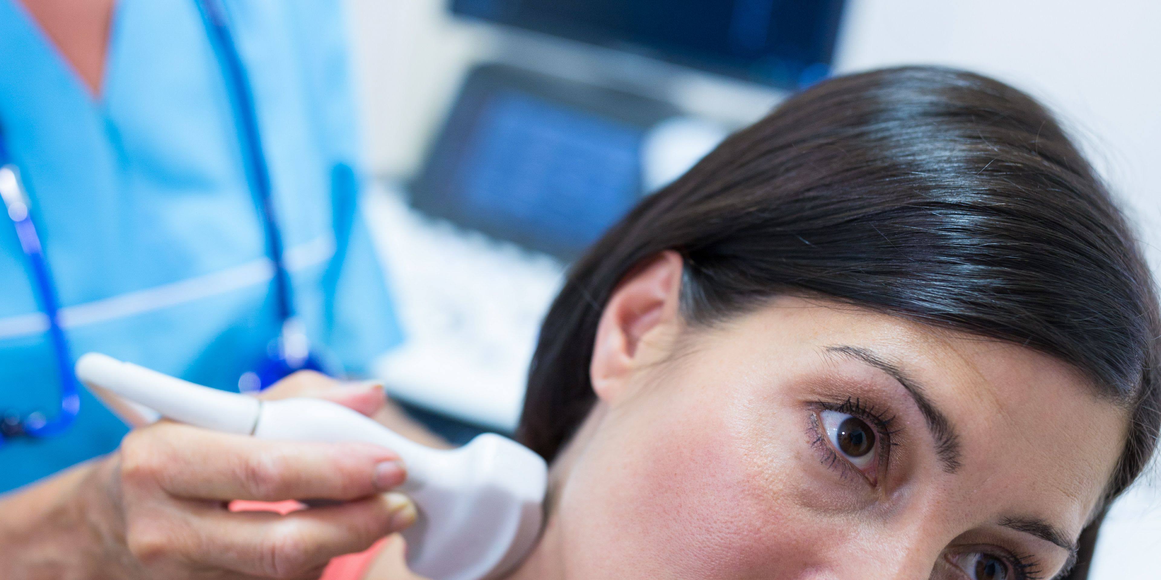 Woman getting ultrasound of a thyroid from doctor